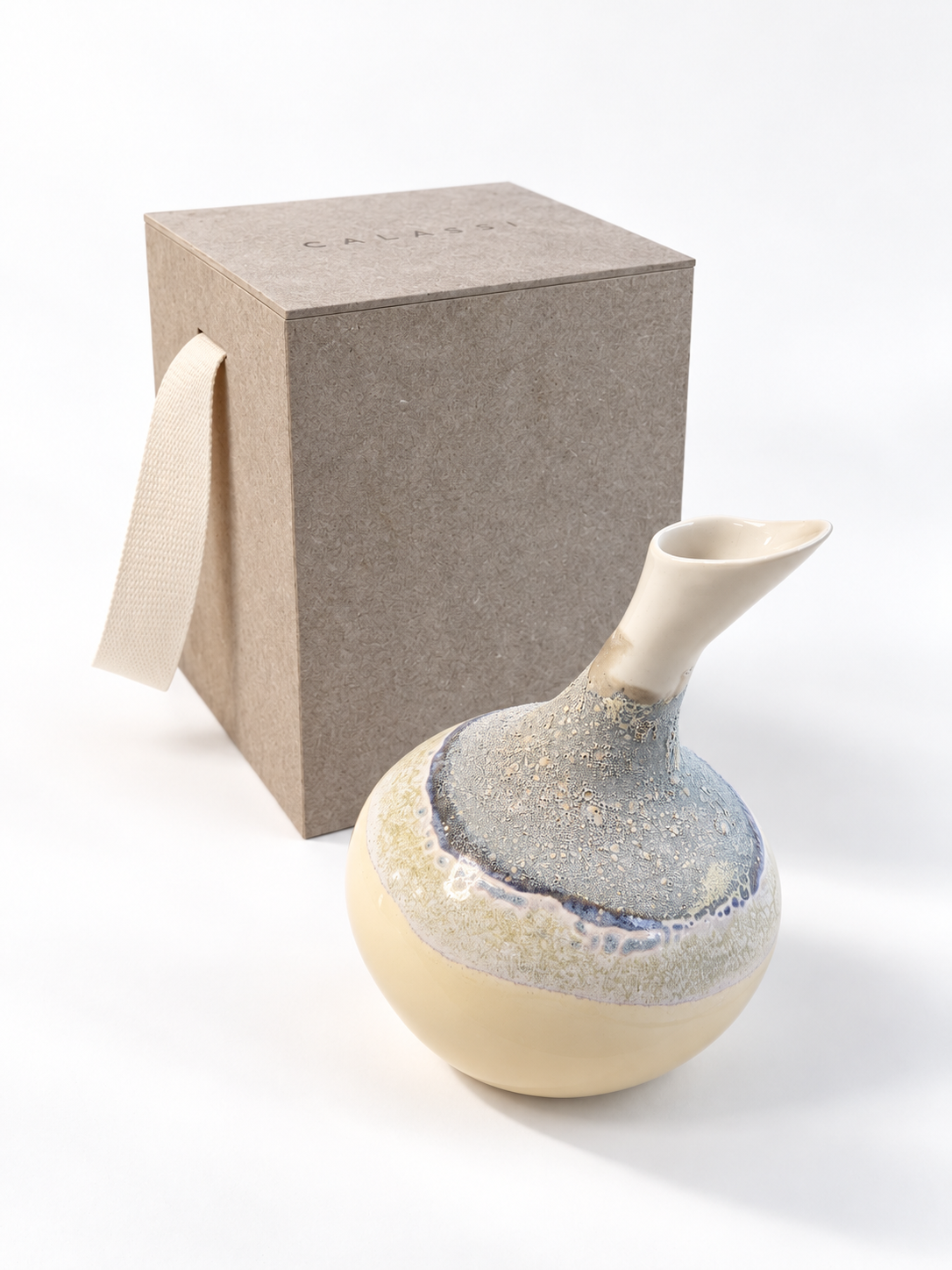 CALASSI ZEN Chardonnay vessel, creamy yellow with a sea-foam glaze neck, beside its kraft gift box